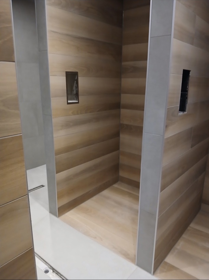 Begehbare Dusche mit Fliesen in Holzoptik und Wandnischen